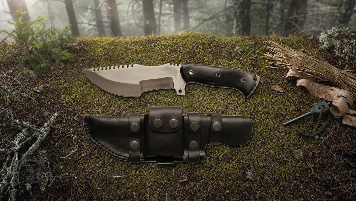 Tracker D2 steel knife with a black Micarta handle on the forest floor beside a ferro rod and tinder